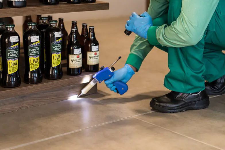 Técnico da Desinservice aplicando tratamento em gel contra formigas.