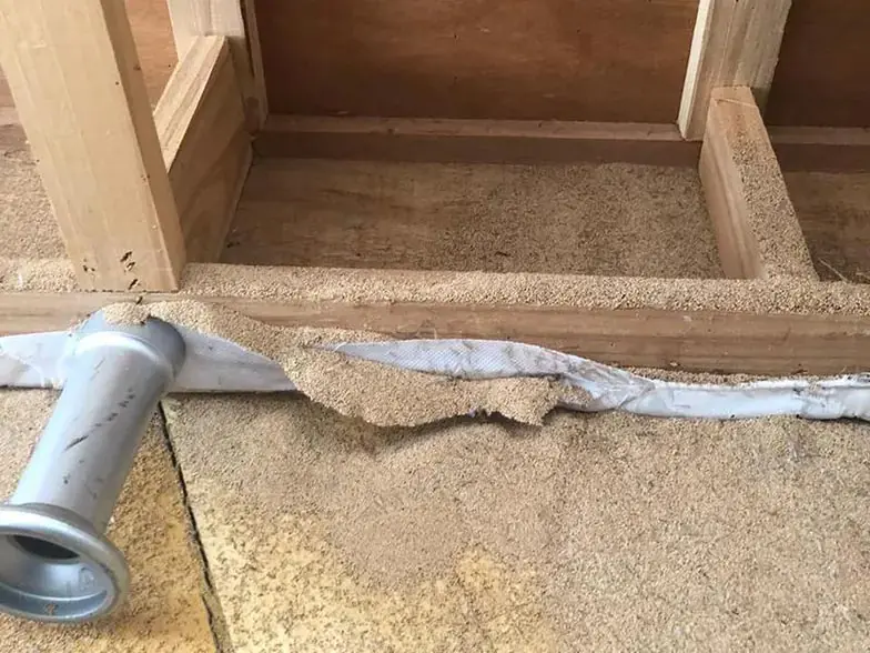 Grande quantidade de excrementos de cupins no interior de uma cama.